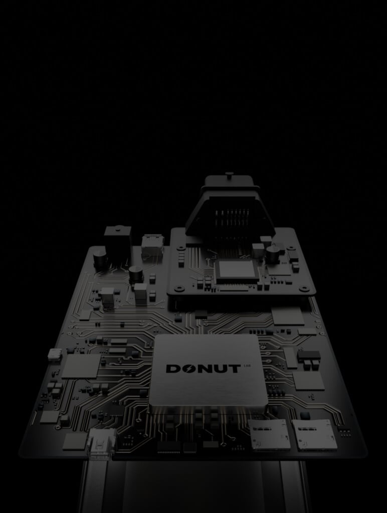 Close-up of a circuit board with "DONUT" labeled in the center. Various electronic components are visible, connected by intricate pathways. The background is dark, highlighting the board.