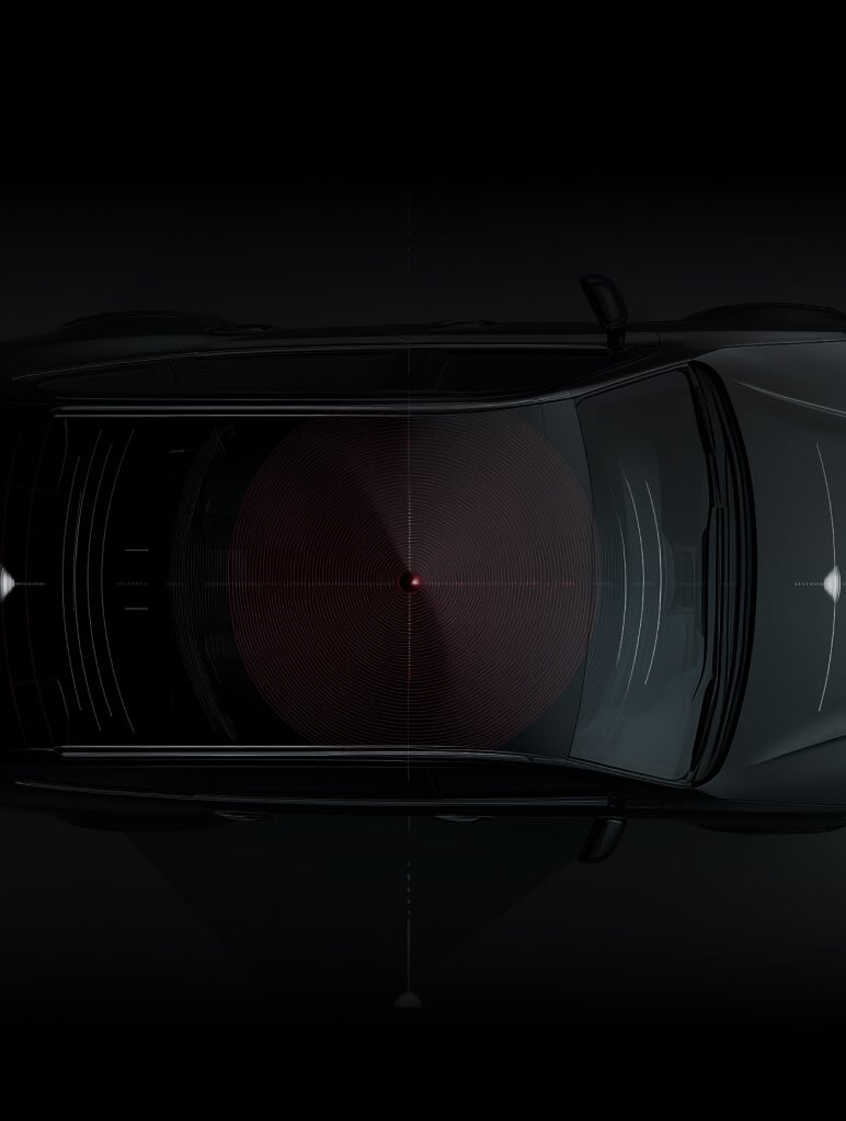 Top view of a car in low light, showing a radar or sensor system visualized as circular patterns emanating from the center. The vehicle is sleek and dark, with emphasis on the technology.