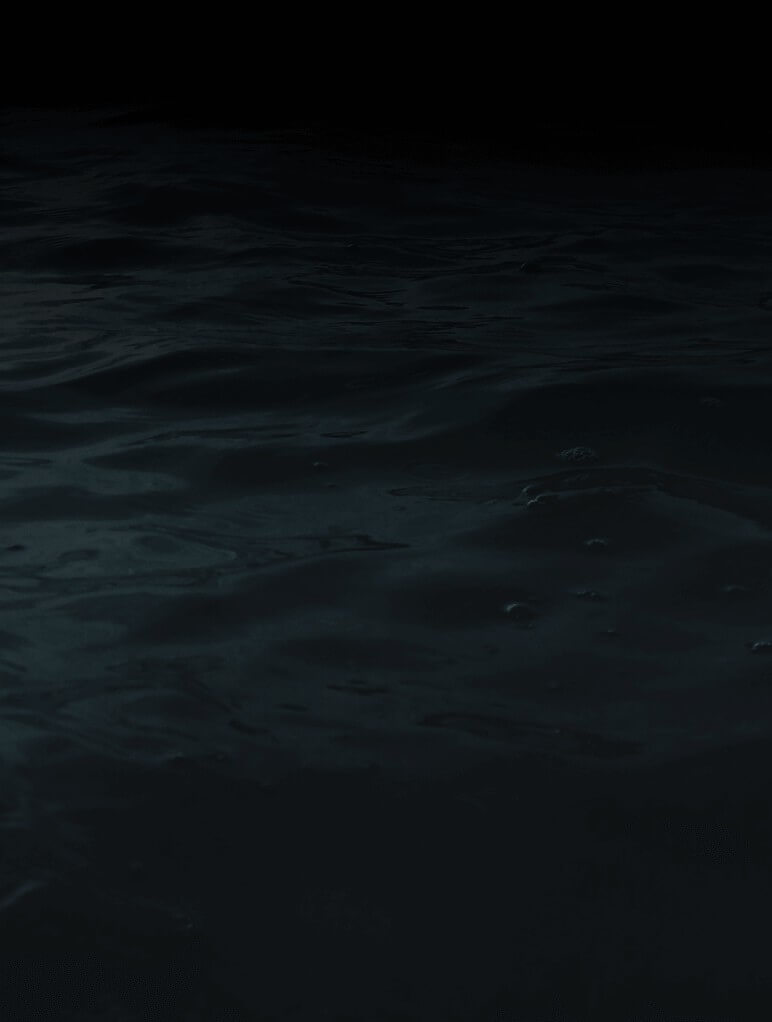 A dark, mysterious body of water with gentle ripples and subtle reflections under a dim light, creating a tranquil yet enigmatic atmosphere. The surface appears calm, and the background fades into black.